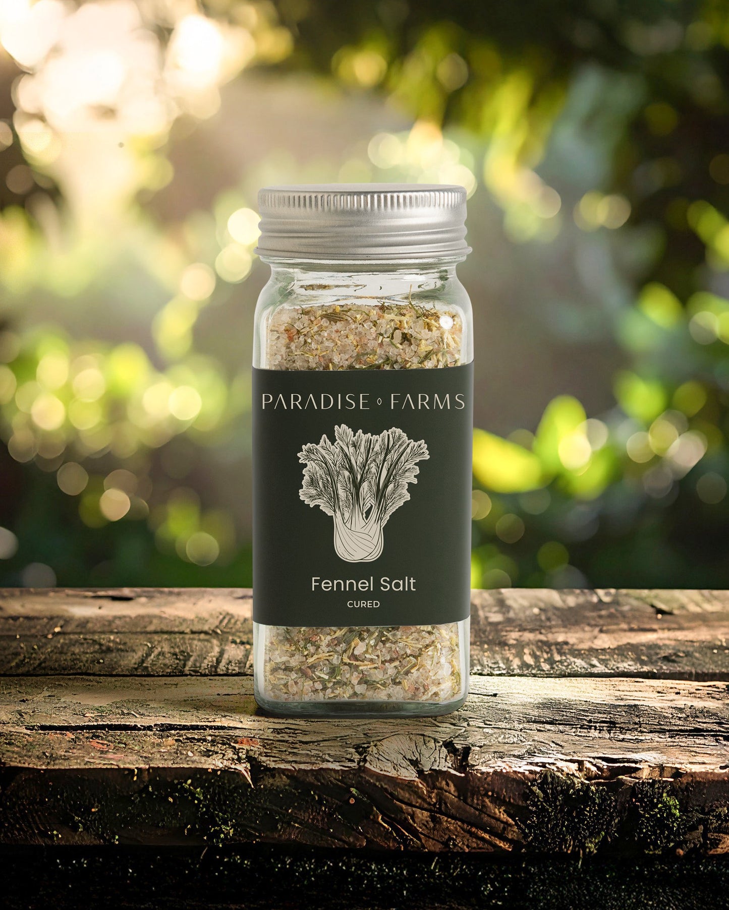 Jar of Paradise Farms Fennel Salt on a wooden surface with a blurred natural background